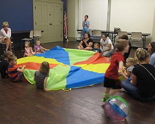Neighbors | Alexis Bartolomucci.Children hid stuffed animals under the parachute while another child had to guess what color the animals were under during the Boardman library story time on Aug. 17.
