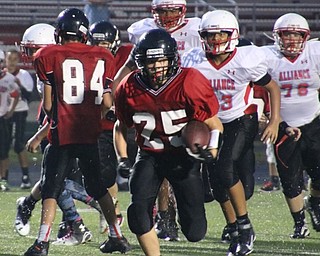 Neighbors | Submitted.Canfield Village Middle School's Michael Crawford (25) is pictured bursting through the Alliance defense on Aug. 31.