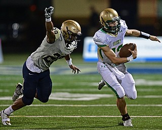 AKRON, OHIO - SEPTEMBER 9, 2016: Quarterback Jared Fabry #13 of Ursuline runs the football while being chased from behind by Arison Sanders #29 of Hoban in the third quarter of their game Friday night at Hoban High School. DAVID DERMER | THE VINDICATOR