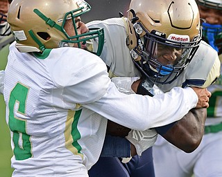 AKRON, OHIO - SEPTEMBER 9, 2016: Running back Todd Sibley #23 of Hoban runs through the tackle of TreZahn Dunlow #6 of Ursuline during the first half of their game Friday night at Hoban High School. DAVID DERMER | THE VINDICATOR