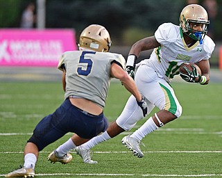 AKRON, OHIO - SEPTEMBER 9, 2016: Dawalyn Washington #10 of Ursuline runs with the football after a reception while Nate Bauer #5 of Hoban breaks down for the tackle during the first half of their game Friday night at Hoban High School. DAVID DERMER | THE VINDICATOR