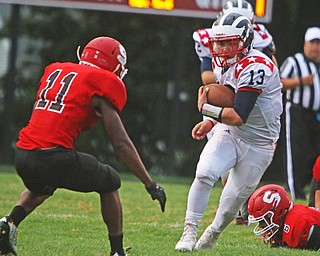 Niles quarterback Tyler Srbinovich (13) cuts upfield while avoiding a tackle by Demond Clark (11) of Struthers during the first quarter of Friday nights matchup at Struthers High School.  Dustin Livesay  |  The Vindicator  9/9/16  Struthers.