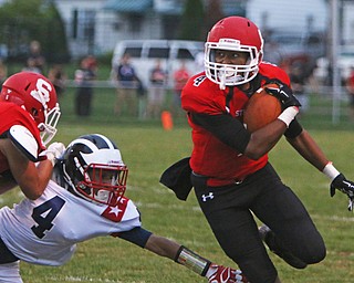 Jacob Shaffer (4) of Struthers picks up a block while avoiding a tackly attempt by Tre Martin (4) of Niles during the first quarter of Friday nights matchup at Struthers High School.  Dustin Livesay  |  The Vindicator  9/9/16  Struthers.