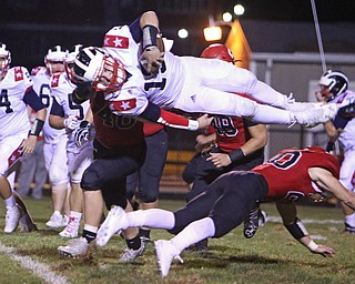 Niles quarterback Tyler Srbinovich (13) dives over a tackle by Brandon Golias (20 of Struthers in an attempt to pick up a first down but comes up short during the third quarter of Friday nights matchup at Struthers High School.  Dustin Livesay  |  The Vindicator  9/9/16  Struthers.