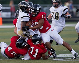 MICHAEL G TAYLOR | THE VINDICATOR- 9-16-16-  1st qtr., Austintiown's #10 Larry Harrinton (left) and teammates stop Harding's #1 Lynn Bowden for a short gain. Warren G. Harding Raiders vs Austintown Fith Falcons at Falcon Stadium in Austintown, OH.