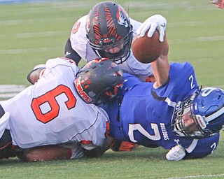 Poland runningback Reid Gould (2) reaches for extra yards to pick up a first down while being tackled by Howland's Shawn Carr (6) and George Beatty-Marsh (2) during the first quarter of Friday nights matchup at Poland High School.   Dustin Livesay  |  The Vindicator  9/16/16  Poland Seminary High School.