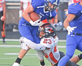 Howland's Stephen Baugh (23) wraps up Poland running back Reid Gould (2) in the backfield during the first quarter of Friday nights matchup at Poland High School.   Dustin Livesay  |  The Vindicator  9/16/16  Poland Seminary High School.
