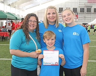 Gavin Loomis (center) of Austintown holds up the sticker with his name on it as he poses for a picture with (L-R) his cousin Sarah Livesay of Boardman,mother Christine Loomis, and sister Payton Loomis of Austintown before the start of the Heart Walk at the WATTS on the campus of Youngstown State University on Saturday morning. Dustin Livesay  |  The Vindicator  9/17/16  WATTS