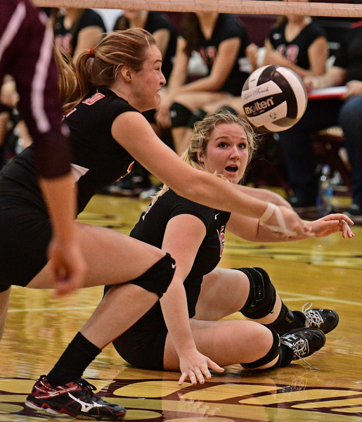 BOARDMAN, OHIO - SEPTEMBER 20, 2016: Madison Johns #25 of Canfield watches the ball fall toward the ground while teammate Natalie Maras #31 keeps the ball alive during the third set of their match Tuesday night at Boardman High School. DAVID DERMER | THE VINDICATOR