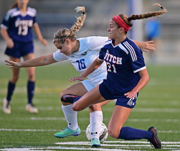 HUBBARD, OHIO - SEPTEMBER 21, 2016: Sydney Newell #16 of Hubbard and Lauren Dolak #21 of Fitch fall to the ground while getting tangled up battling for the ball during the first half of their game Wednesday night at Hubbard Memorial Stadium. DAVID DERMER | THE VINDICATOR