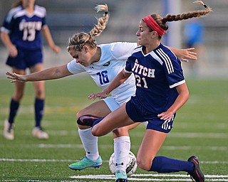 HUBBARD, OHIO - SEPTEMBER 21, 2016: Sydney Newell #16 of Hubbard and Lauren Dolak #21 of Fitch fall to the ground while getting tangled up battling for the ball during the first half of their game Wednesday night at Hubbard Memorial Stadium. DAVID DERMER | THE VINDICATOR