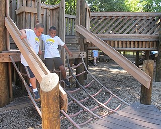 Neighbors | Alexis Bartolomucci.Two children in Camp FRIEND walked down the playground equipment together at Boardman Park during the last day of camp on Aug. 26.