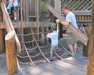 Neighbors | Alexis Bartolomucci.One of the leaders at Camp FRIEND helped one of the children walk up a piece of equipment at Boardman Park on Aug. 26.