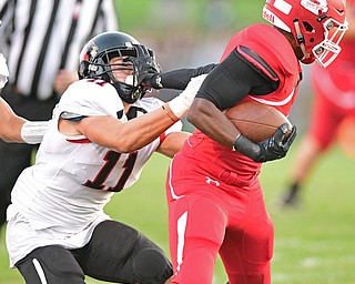 STRUTHERS, OHIO - SEPTEMBER 23, 2016: Regal Reese #21 of Struthers stiff arms Will Dawson #11 of Canfield as he runs the football during the first half of their game Friday night at Struthers High School. DAVID DERMER | THE VINDICATOR