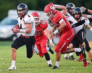 STRUTHERS, OHIO - SEPTEMBER 23, 2016: Paul Breinz #4 of Canfield runs the football in the open field after running past AJ Musolino #18 and Robbie Best #20 of Struthers during the first half of their game Friday night at Struthers High School. DAVID DERMER | THE VINDICATOR