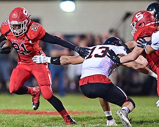 STRUTHERS, OHIO - SEPTEMBER 23, 2016: Regal Reese #21 of Struthers runs through the arm tackle of Jared Clark #13 of Canfield during the first half of their game Friday night at Struthers High School. DAVID DERMER | THE VINDICATOR