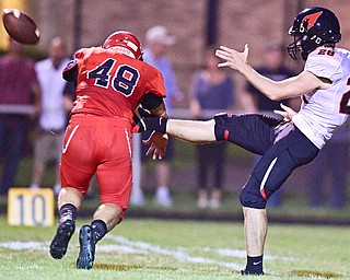 STRUTHERS, OHIO - SEPTEMBER 23, 2016: Connor Calabrette #48 of Struthers tips the punt off the foot of Ian Kristan #28 of Canfield during the first half of their game Friday night at Struthers High School. DAVID DERMER | THE VINDICATOR