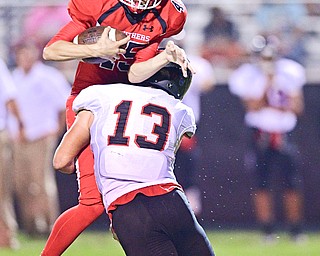 STRUTHERS, OHIO - SEPTEMBER 23, 2016: Kicker Derek Guzzo #45 of Struthers is brought down hard by Jared Clark #13 of Canfield after he fielded the ball on a high snap on a PAT, during the first half of their game Friday night at Struthers High School. DAVID DERMER | THE VINDICATOR