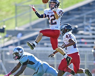 YOUNGSTOWN, OHIO - SEPTEMBER 24, 2016: J.C. Mikovich #22 of Fitch looks the ball into his hands while flying through the air to intercept a pass intended for Michael Lawrence #2 of East during the first half of their game Saturday afternoon at Rayen Stadium. Fitch won 38-6. DAVID DERMER | THE VINDICATOR..Emmanuel Dawkins #42 of Fitch pictured.
