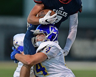 WARREN, OHIO - SEPTEMBER 24, 2016: Evan Boyd #7 of JFK is wrapped up by Ryan Neely #54 of Steubenville Central Catholic after he attempted to hurdle him during the first half of their game Saturday night at Mollenkopf Stadium. DAVID DERMER | THE VINDICATOR