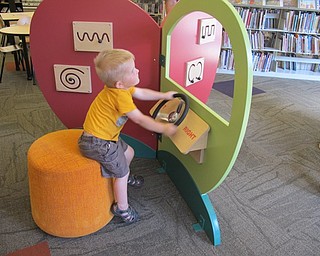 Neighbors | Alexis Bartolomucci.One of the boys attending the grand opening of the new learning centers at the Boardman library on Sept. 10 played with the steering wheel which helped with learning right and left.