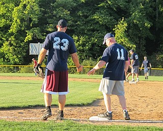 Neighbors | Alexis Bartolomucci.Two of the players from the Boardman police team high-fived each other after making it to first base during the Battle of Badges charity baseball game on Sept. 12 at the Field of Dreams.
