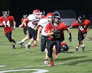 Neighbors | Submitted.Canfield's Michael Crawford (25) is pictured sprinting through the Struthers defense at the game on Sept. 21. Canfield claimed victory with a score of 34-20.