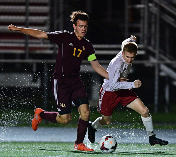 CANFIELD, OHIO - SEPTEMBER 29, 2016: Tanor English #3 of Canfield and Mitch McConnell #17 of South Range chase after the ball through a puddle during the first half of their game Thursday night at Canfield High School. DAVID DERMER | THE VINDICATOR