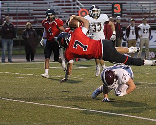Nikos Frazier | The Vindicator..Cardinal Jake Cummings(7) dives over Spartan Mike Melewski(25) for a touchdown in the first quarter at Canfield High School on Friday, Sept. 30, 2016.