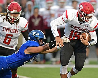 POLAND, OHIO - SEPTEMBER 30, 2016: AJ Musolino #18 of Struthers runs the football while slipping out of a tackle from Nick Miller #85 of Poland during the first half of their game Friday night at Poland High School. DAVID DERMER | THE VINDICATOR