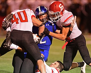 POLAND, OHIO - SEPTEMBER 30, 2016: Reid Gould #2 of Poland is brought down aggressively by Nate Richards #40, AJ Musolino #18 and Nick Adams #2 of Struthers during the first half of their game Friday night at Poland High School. DAVID DERMER | THE VINDICATOR