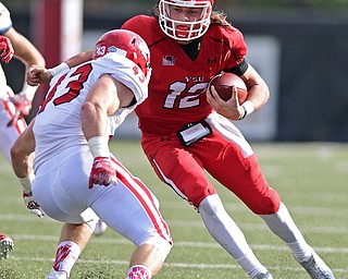 YOUNGSTOWN, OHIO - OCTOBER 1, 2016: Quarterback Ricky Davis #12 of YSU runs the football while trying to avoid being tackled by Jim Litrenta #43 of South Dakota during the first half of their game Saturday afternoon at Stambaugh Stadium. YSU won 30-20. DAVID DERMER | THE VINDICATOR
