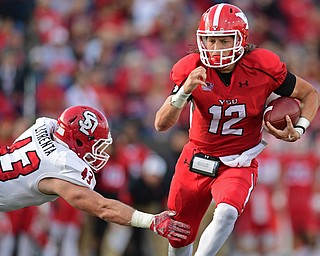 YOUNGSTOWN, OHIO - OCTOBER 1, 2016: Quarterback Ricky Davis #12 of YSU runs the football through the arm tackle of Jim Litrenta #43 of South Dakota during the first half of their game Saturday afternoon at Stambaugh Stadium. YSU won 30-20. DAVID DERMER | THE VINDICATOR