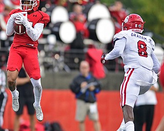 YOUNGSTOWN, OHIO - OCTOBER 1, 2016: Receiver Darien Townsend #21 of YSU leaps to catch a pass after beating the coverage by Tyson Graham Jr. #8 of South Dakota during the second half of their game Saturday afternoon at Stambaugh Stadium. YSU won 30-20. DAVID DERMER | THE VINDICATOR