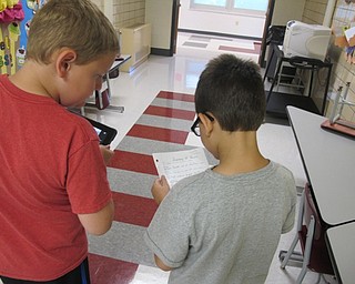 Neighbors | Alexis Bartolomucci.Two fourth-grade students read the maps other fourth-grade students made to try and capture Pokemon characters in the Robinwood Lane Elementary school building on Sept. 16.
