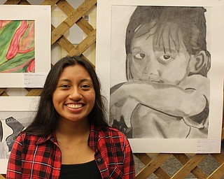 Neighbors | Abby Slanker.Canfield High School sophomore Fiona Lally posed next to her art work as she attended the Canfield High School Art Department’s art show at the Canfield library on Sept. 22.