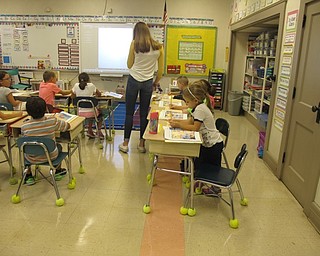 Neighbors | Alexis Bartolomucci.Jensyn Orr walked around Karen Vasko's class on Sept. 20 as part of the Big Dog, Little Dog program helping the students with their work.