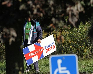 Nikos Frazier | The Vindicator..A Trump Supporter holds a "Hillary for Prison 2016" sign across the street from the Western Reseve Building Trade Hall on McClurg Road in Youngstown before Former President Bill Clinton spoke at a breakfast event.