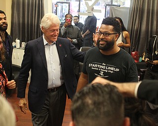 Nikos Frazier | The Vindicator..Former President Bill Clinton walks into Starting Lineup Barber shop in downtown Youngstown during a surprise stop during his bus tour of the Mahoning Valley.