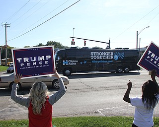Nikos Frazier | The Vindicator..Trump supporters hold up "Trump Pence" signs as Former President Bill Clinton's bus passes them after leaving the Trumbull County Hillary for America offices in Warren .