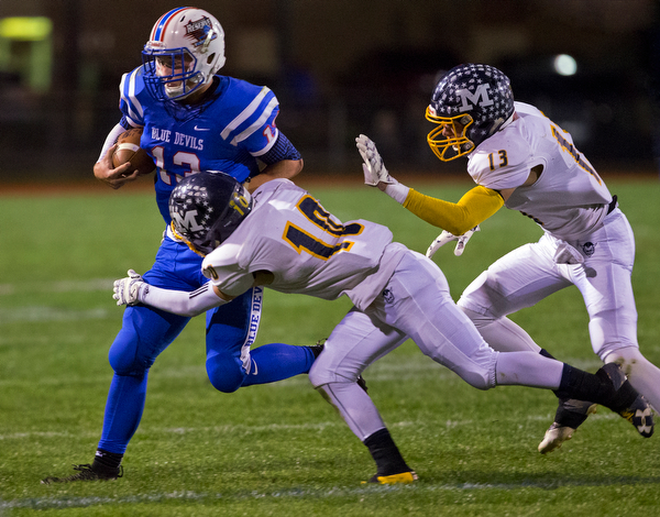 MICHAEL G TAYLOR | THE VINDICATOR- 10-07-16- 1st qtr, Reserve's #13 Wyatt Larimer is brought down by McDonald's #10 Josh Celli and #13 Dylan Portolese. McDonald Blue Devils vs Western Reserve Blue Devils at Western Reserve Stadium in Berlin Center, OH.