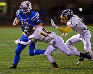 MICHAEL G TAYLOR | THE VINDICATOR- 10-07-16- 1st qtr, Reserve's #13 Wyatt Larimer is brought down by McDonald's #10 Josh Celli and #13 Dylan Portolese. McDonald Blue Devils vs Western Reserve Blue Devils at Western Reserve Stadium in Berlin Center, OH.