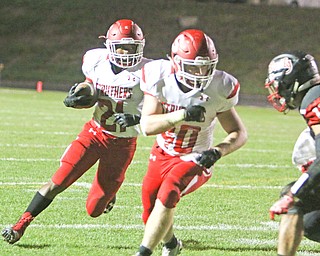 Regal Reese (21) of Struthers follows his blocker Nate Richards (40) who picked up a key block on Campbell Memorial's Yianni Koullias (11) during the second quarter of Friday nights matchup at Campbell Memorial High School.  Dustin Livesay  |  The Vindicator  10/7/16  Campbell.