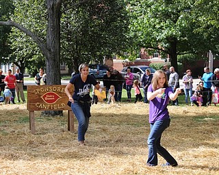 Neighbors | Abby Slanker.Jill Barton (left), pastor of Rush Church, served as master of ceremonies and was joined by Pastor Natalie (right), Rush Church children’s pastor, as they warmed up the children to start the annual Canfield Dairy Queen Pumpkin Hunt on Sept. 24.