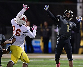 WARREN, OHIO - OCTOBER 14, 2016: Lynn Bowden #1 of Warren Harding throws a touchdown pass to Jalen Hooks #6 (not pictured) while avoiding pressure from Andre McCoy #26 of Mooney during the first half of their game Friday nights game at Molenkamp Stadium. DAVID DERMER | THE VINDICATOR