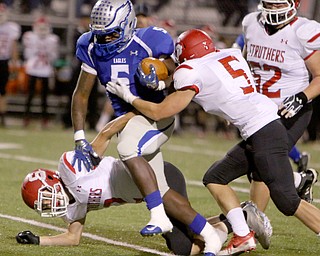 Hubbard's Rafael Morales (5) tries to break through the tackles by Struthers defenders Nick Adams (2) and Trent Stocker (5) during the first quarter of Friday nights matchup at Hubbard High School.  Dustin Livesay  |  The Vindicator  10/14/16 Hubbard