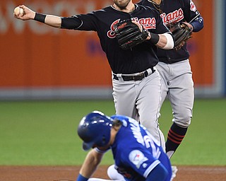 Toronto Blue Jays' Josh Donaldson (20) is forced out at second base as Cleveland Indians second baseman Jason Kipnis turns an inning-ending double play during the fourth inning in Game 5 of baseball's American League Championship Series in Toronto, Wednesday, Oct. 19, 2016. Toronto's Edwin Encarnacion was out at first. (Frank Gunn/The Canadian Press via AP)