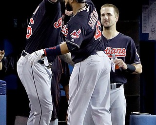Cleveland Indians' Carlos Santana celebrates in the dugout after his home run during the third inning in Game 5 of baseball's American League Championship Series against the Toronto Blue Jays in Toronto, Wednesday, Oct. 19, 2016. (AP Photo/Charlie Riedel)