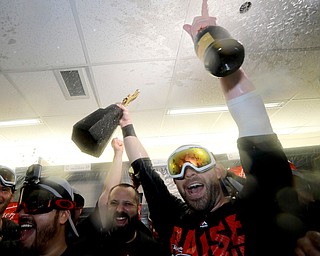 Cleveland Indians second baseman Jason Kipnis celebrates in the locker room with the American League's trophy after their 3-0 win against the Toronto Blue Jays in Game 5 of baseball's American League Championship Series in Toronto, Wednesday, Oct. 19, 2016. The Indians advance to the World Series. (AP Photo/Charlie Riedel)