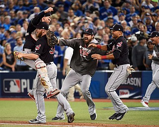 Cleveland Indians relief pitcher Cody Allen (37), cather Roberto Perez (55) and teammates Andrew Miller and Coco Crisp celebrate the team's 301 victory over the Toronto Blue Jays during Game 5 of the baseball American League Championship Series, in Toronto on Wednesday, Oct. 19, 2016. (Nathan Denette/The Canadian Press via AP)